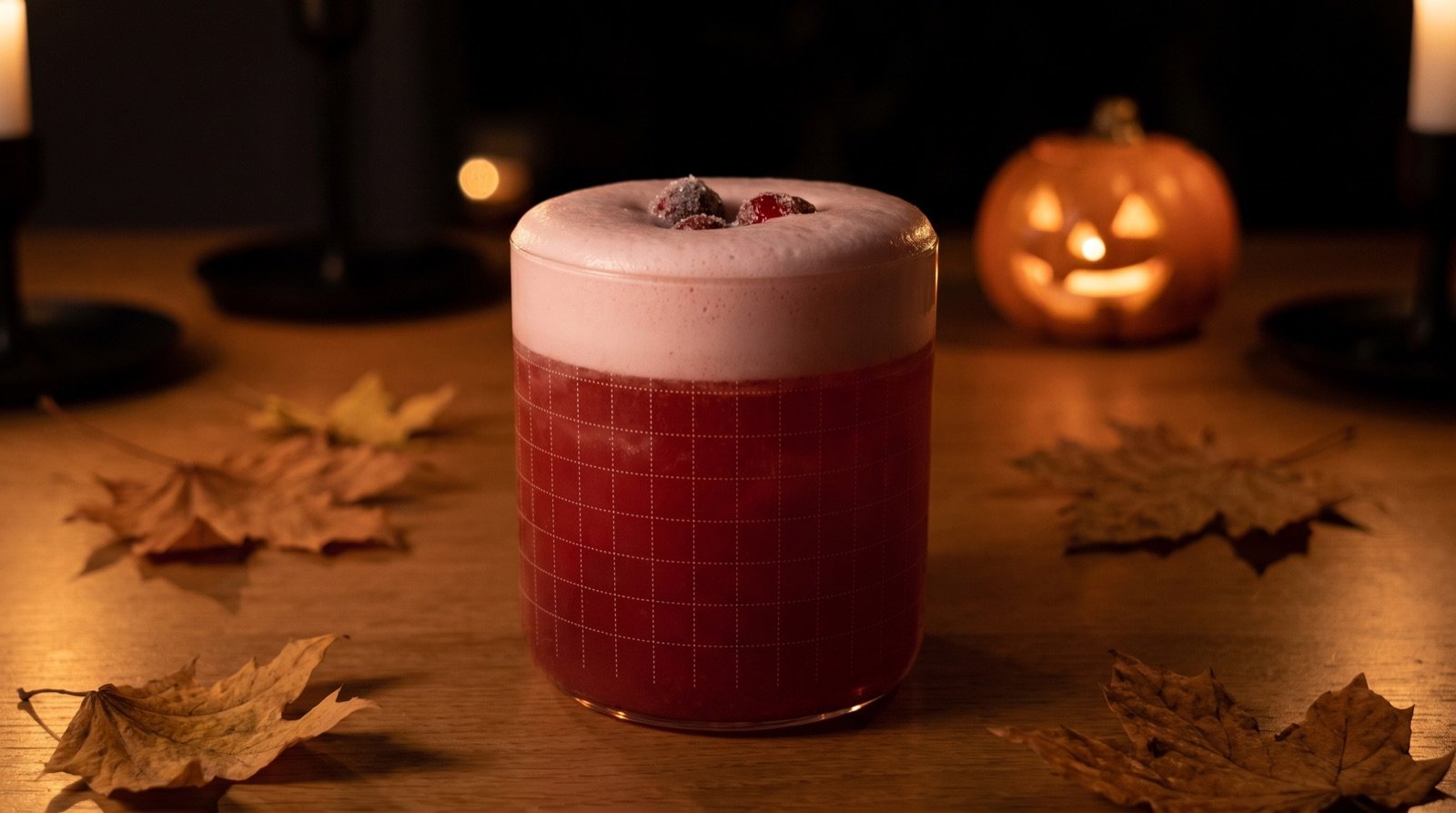 Cranberry cinnamon sour rouge avec sa mousse et ses cranberries givrées, devant une citrouille d'Halloween