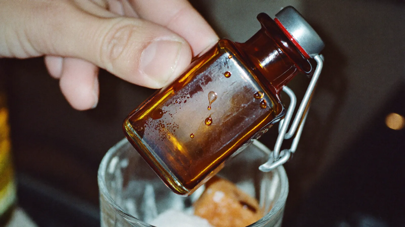 Quelques traits de bitters versés au-dessus d'un verre contenant un sucre