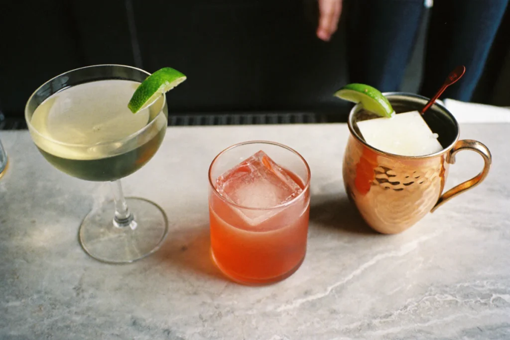 Daiquiri, Negroni et Moscow Mule côte à côte sur un comptoir en marbre