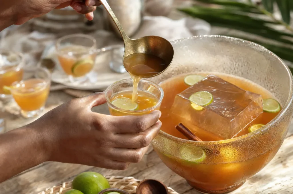 Service du punch à la louche dans un bol avec un grand bloc de glace