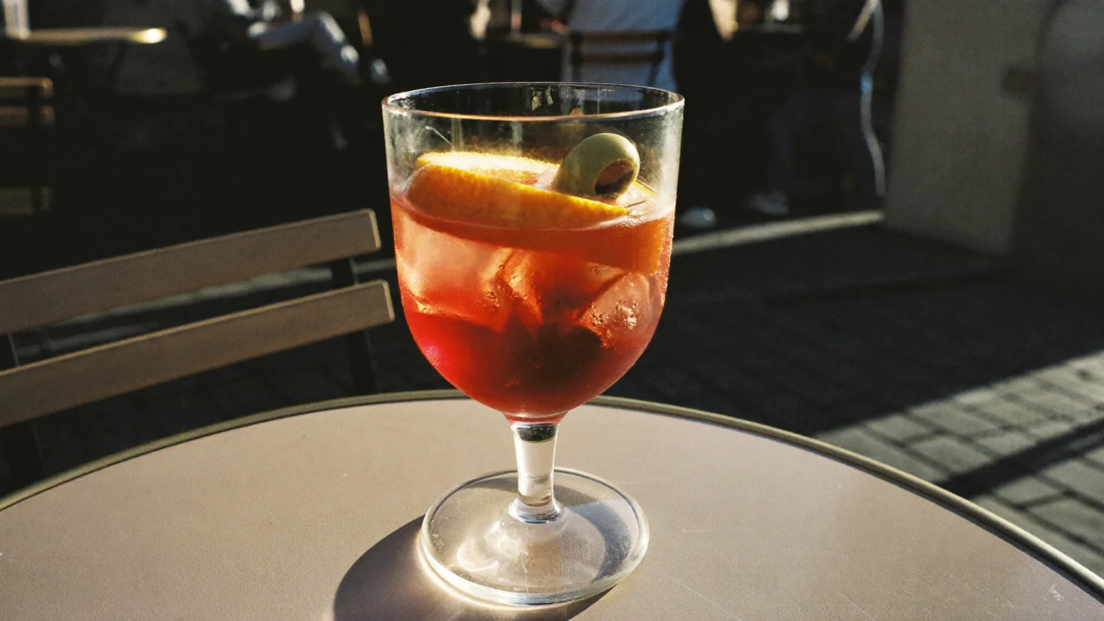 Verre de vermouth rouge sur glace avec une tranche d'orange en terrasse