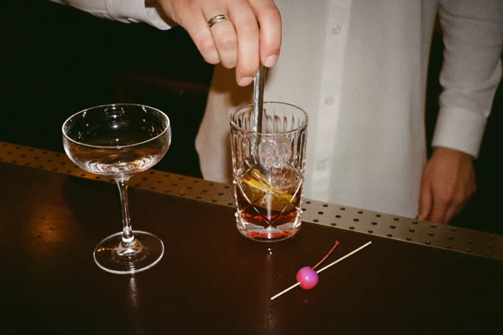 Cocktail au vermouth remué à la cuillère de bar dans un verre en cristal
